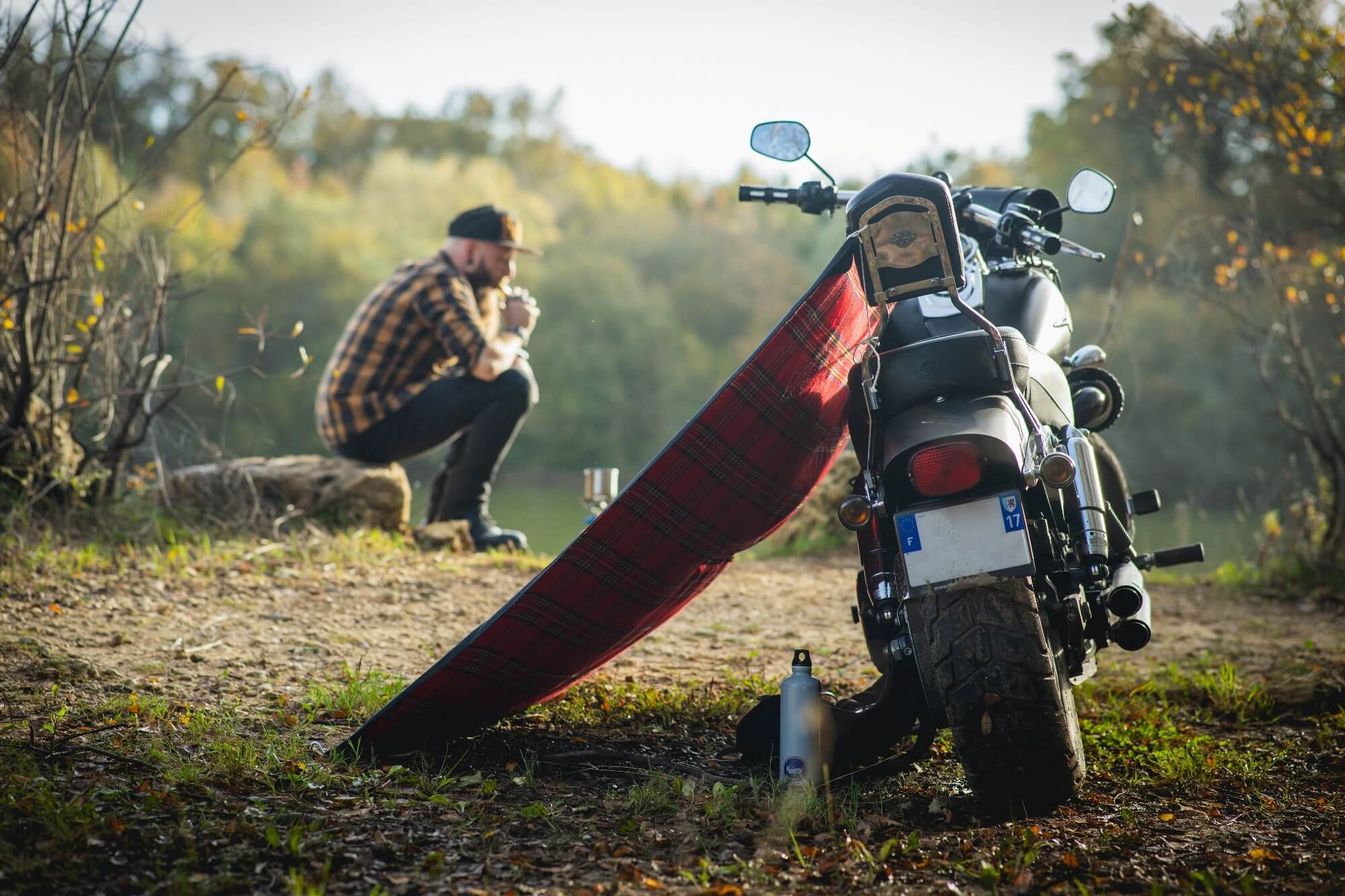 Motard en blouson de cuir Zolki en bivouac près de sa moto